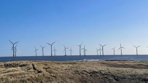 Superted A sunny view of a number of wind turbines off Redcar beach.