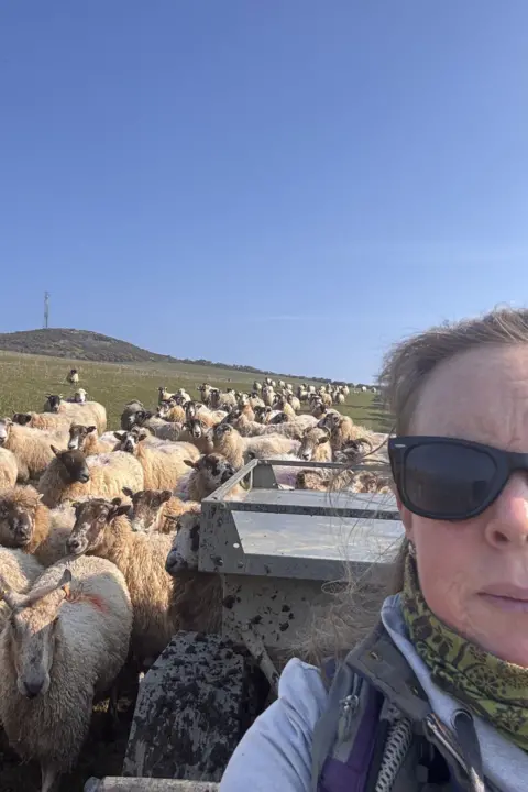 ANNA KERRUISH A selfie of Anna on a quadbike with the flock of sheep behind her.