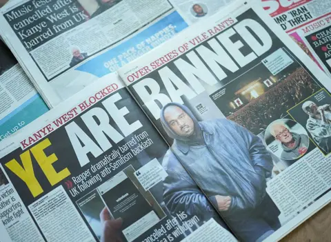 Getty Images A spread of newspapers showing coverage of Kanye West being banned from entering the UK