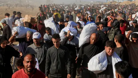 Palestinians carry aid supplies from the U.S.-backed Gaza Humanitarian Foundation, in Khan Younis. 