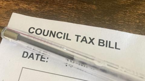 The top of a council tax bill with a pen resting on top of it.