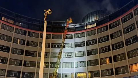 London Fire Brigade Fire crews tackle fire on top of tall building