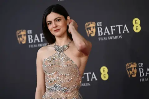 Getty Images Monica Barbaro in a fitted, sparkling gown in pale colours with jewels encrusted into the fabric