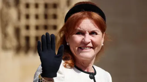 EPA Britain's Sarah Ferguson, Duchess of York, wears a black headband and black gloves, with a white and black blouse, waves to something off camera. 