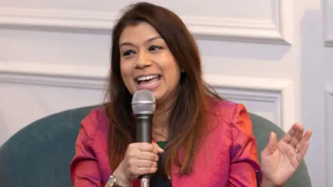 Getty Images Tulip Siddiq  holds her microphone while giving a speech 