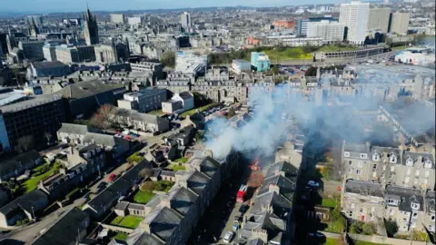 Smoke billowing rooftops in Aberdeen city centre.