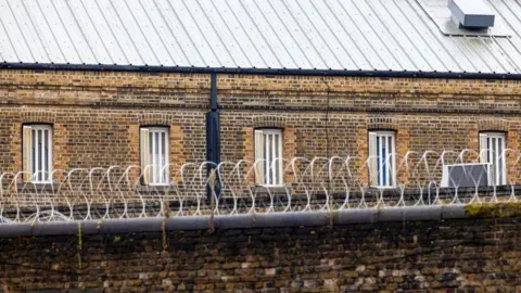 Getty Images Image of prison walls with barbed wire