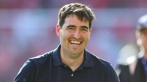 Bournemouth boss Andoni Iraola smiles on the touchline