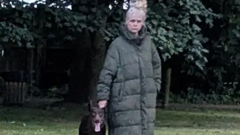 A woman in a long green puffer jacket. 