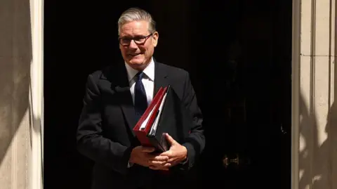 Prime Minister Keir Starmer departs 10 Downing Street to attend his final Prime Minister's Questions at the Parliament in London. He is carrying some files.