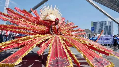 Carnival parade showing man with red costume