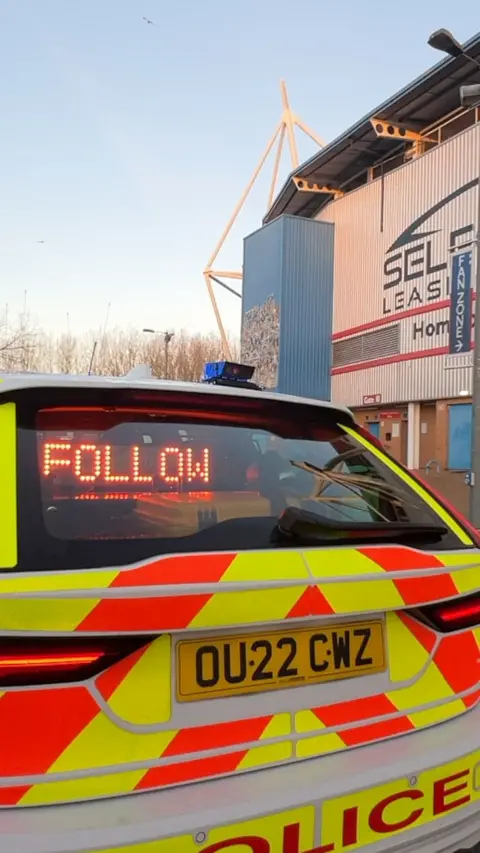The back of a police car with the words 'follow'.