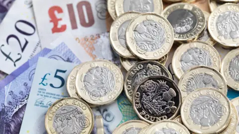 Pound coins and bank notes - stock photo