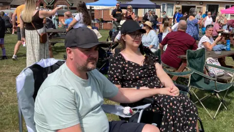 Bryony and James sitting beside each other at a charity event at a local community playing field in Jacksdale in Nottinghamshire. 