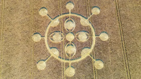 StillPho ToMalone An aerial view of a crop circle in a field.