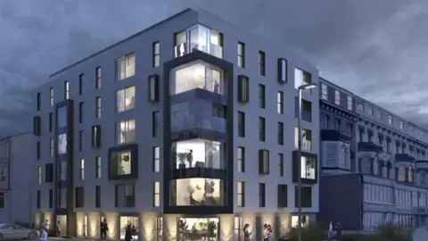 An artist’s impression of The New Ambassador development planned for the former Ambassador Hotel site on Blackpool Promenade. The building is on a corner, in a modern style with large glass windows. 