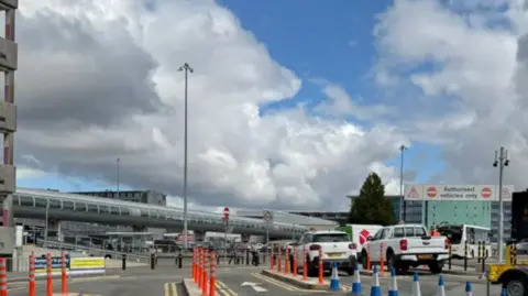 Manchester Airport General view of traffic and parking areas outside of Manchester Airport on a cloudy day.