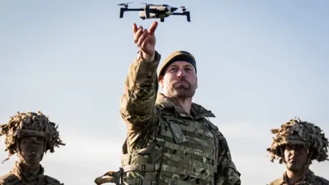 PA Media Prince of Wales in uniform of Colonel of the Welsh Guards, during a visit to the 1st Battalion Welsh Guards at Salisbury Plain - holding up a drone 