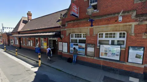 Google maps Google maps image of the front of Newbury station. It's a red brick building with a red train sign in the middle of the building. 