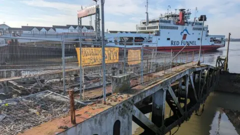 Associated British Ports/ SCC planning portal The Whale roadway section and buffer pontoon of a Mulberry Harbour to the east of Royal Pier at Town Quay in Southampton. A Red Funnel Ferry is sailing nearby. It is a clear day.