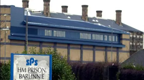 PA Media The exterior of Barlinnie Prison, a brick building with a blue roof and six chimneys