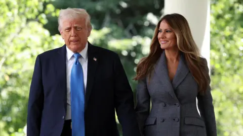 Donald Trump walking with Melania Trump both wearing suits