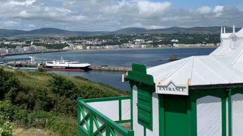 The white and green building, a sign reads entrance, you can see the Manannan in the background and Douglas Bay.