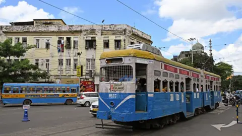 AFP In this photo taken on September 8, 2024, passengers commute to work by tram on a street in Kolkata. Calcutta's trams, introduced to the sprawling eastern city in 1873, at the beginning of the Imperial British Raj, were initially horse-drawn, then steam. Electric trams hit the streets in 1900. 