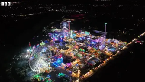 Drone footage high above Hull Fair, the footage has been taken at night and you can see the bright lights of the rides and attractions below.