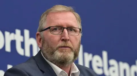 Getty Images Doug Beattie wearing glasses, a blazer and white shirt.