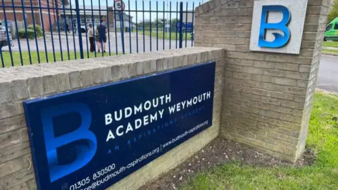 Blue sign at entrance of Budmouth Academy.