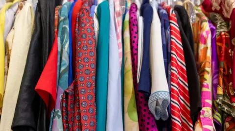 Getty Images An up-close rack of colourful shirts displayed in a shop. 