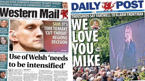 Daily Post front page. Main image Mike Peters, Text: Thousands say farewell to Alarm frontman. We love you Mike. Western Mail front page. Man's face, text: Sam: It's time to make 'cut-throat' regions decision. Story beneath a grey line, text: Use of Welsh 'needs to be intensified'. Stories down the left side: Mike Peters, he is smiling and has long blond hair. Text: Farewell to alarm frontman. Blue box beneath, photo of woman smiling, she has brown hair. Text: Urdd chair winner unveiled. Next blue box beneath has a photo of a man smiling. Text: Liverpool suspect named. Blue box beneath has a photo of a man with a scrum hat on. Text: Jenkins ruled out of tour. 
