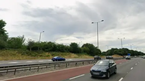 Motorway with taxi lane in red and cars driving in other lanes both ways