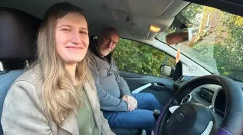 Zoe Johnston on the left and Carl Goodwin in a car, with Ms Johnston sitting in the driver's seat