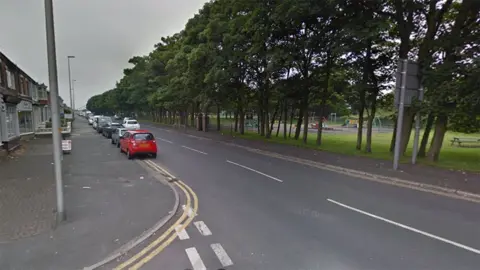 Google Watson Road, Blackpool, showing shops and a children's park