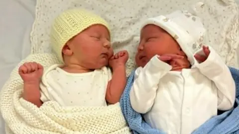 Abi Newborn babies Freddie and Alfie cuddled next to one another. 