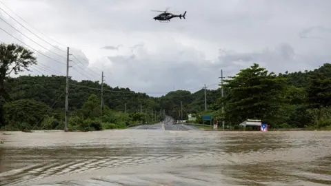 Reuters Police helicopter flies over a flooded area in the aftermath of Tropical Storm Ernesto in Toa Baja, Puerto Rico