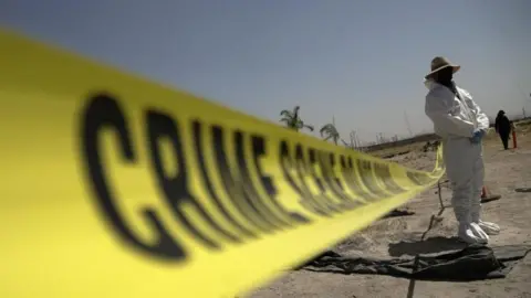 A forensic technician stands next to a cordoned area during a media tour by Jalisco’s Attorney General Office at Izaguirre Ranch, which activists have called a cartel-run "extermination camp," in Teuchitlan, Jalisco state, Mexico March 20, 2025.