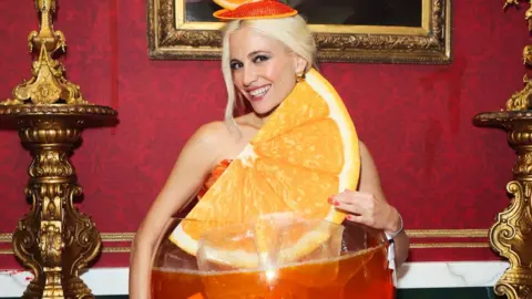 Pixie Lott wearing an Aperol Halloween costume