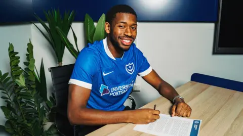 Aji Alese poses for a photo after signing his Portsmouth contract