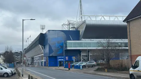 Alice Cunningham/BBC A general view of the outside of Portman Road Stadium. Cars can be seen parked outside the stadium.