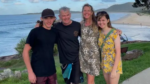 Supplied: Myfanwy Webb A family of four smile at the camera with a beach in the background