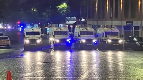 Four PSNI Land Rovers parked in line at Bradbury Place close to Sandy Row at night