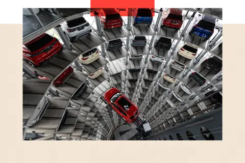 Getty Images A Volkswagen Tiguan car stands on an elevator platform inside one of the twin display towers at the Volkswagen factory - cars line up the tower 