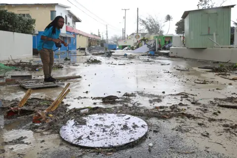 Reuters A man walks along a debris-filled street