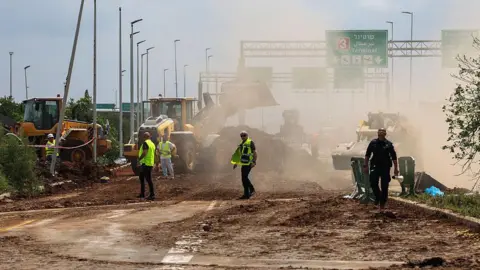 Israeli emergency services clear a road outside Israel's Ben Gurion airport. 