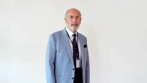 Reform UK A man in a jacket and tie against a white background