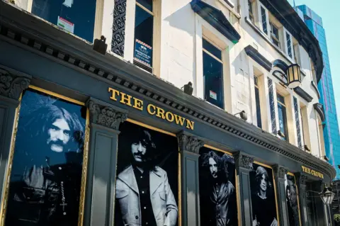 Stacey Barnfield The Crown pub with images of Black Sabbath displayed