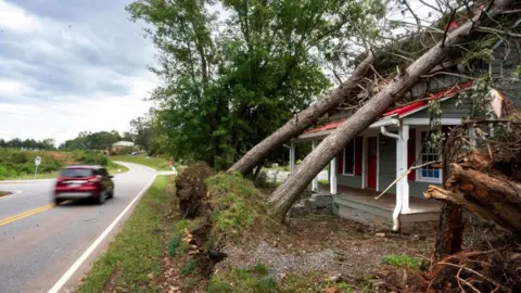 Getty Images A house is damaged by fallen trees